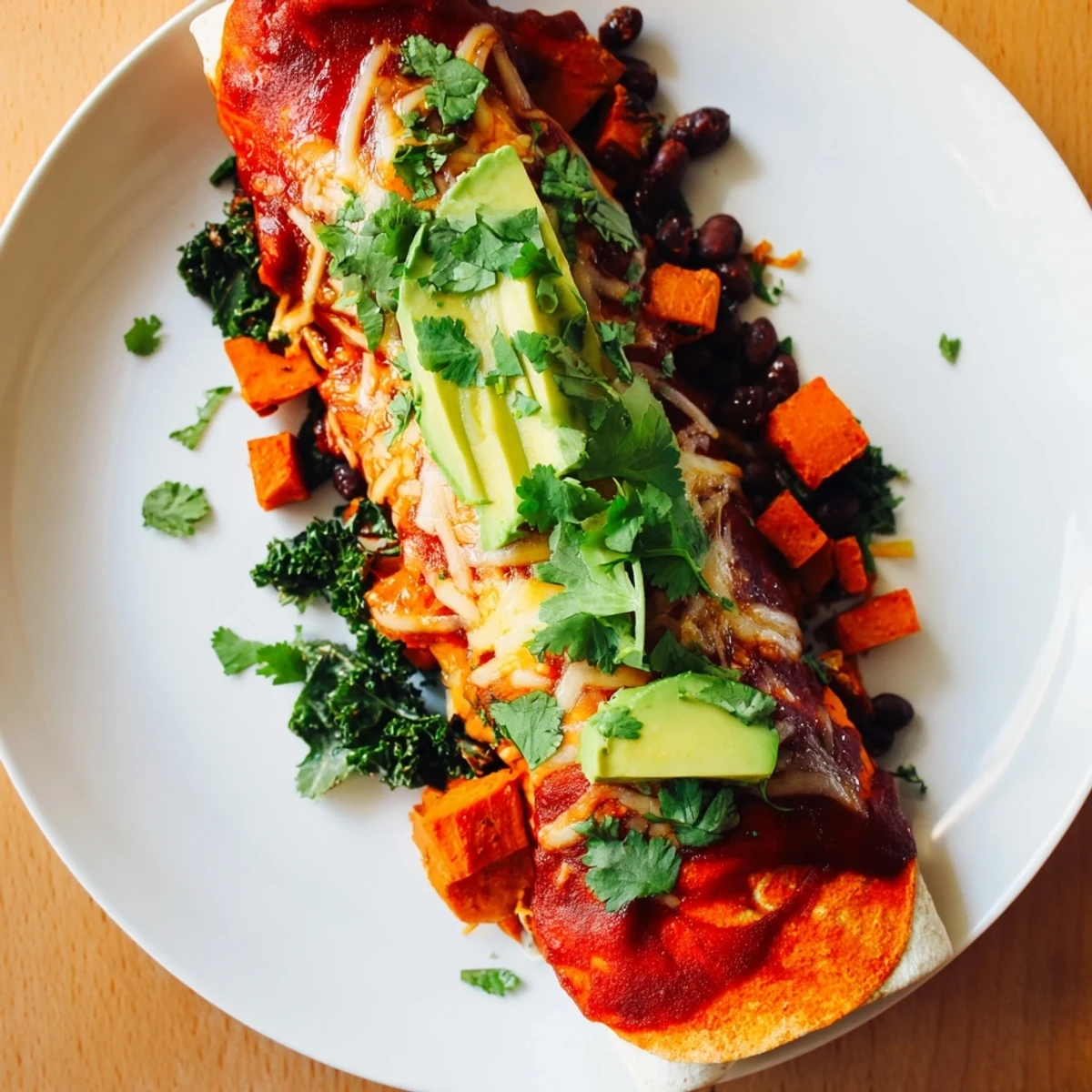 Golden, bubbly One-Pan Sweet Potato, Black Bean & Kale Enchiladas, a vegetarian delight, ready to eat.