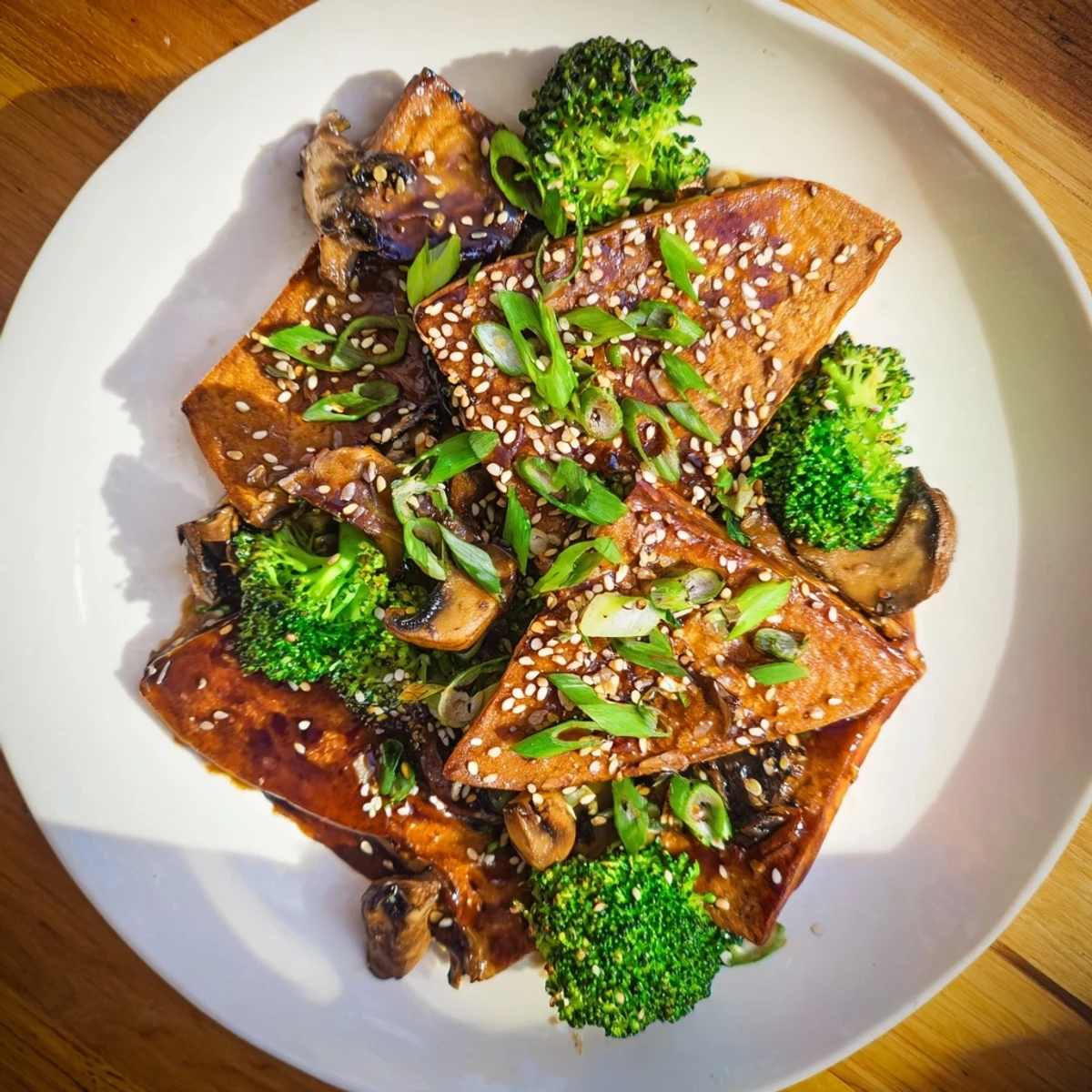Plated Sautéed Tofu Steak with Broccoli, garnished with sesame seeds, looks fresh and delightful.