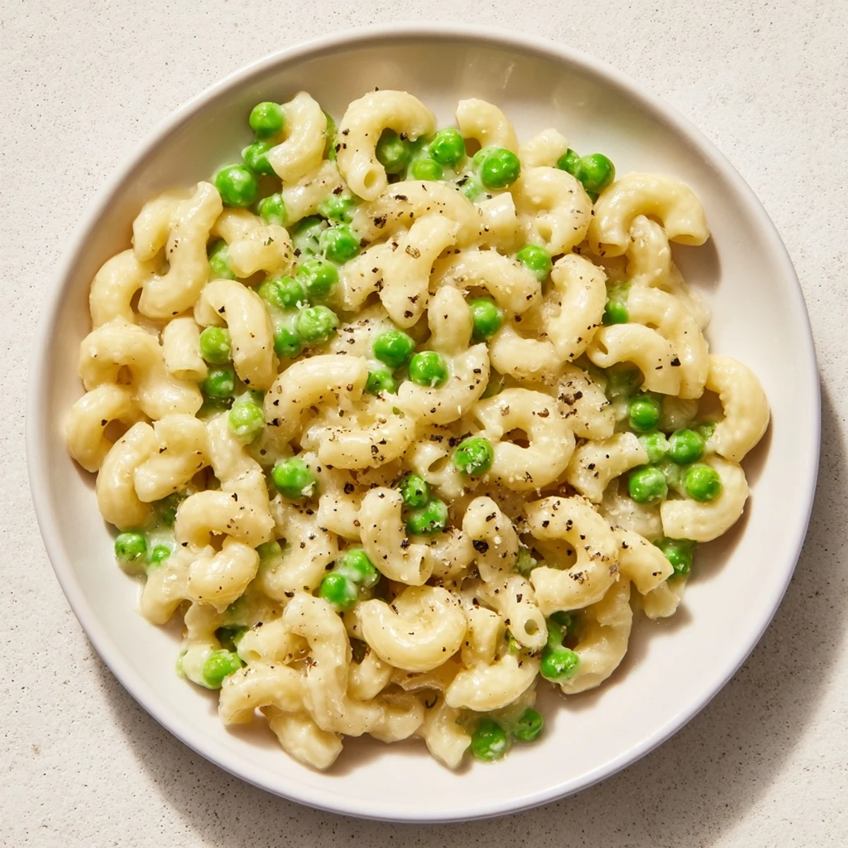Creamy macaroni and peas, a comforting bowl of pasta with hints of parmesan cheese.