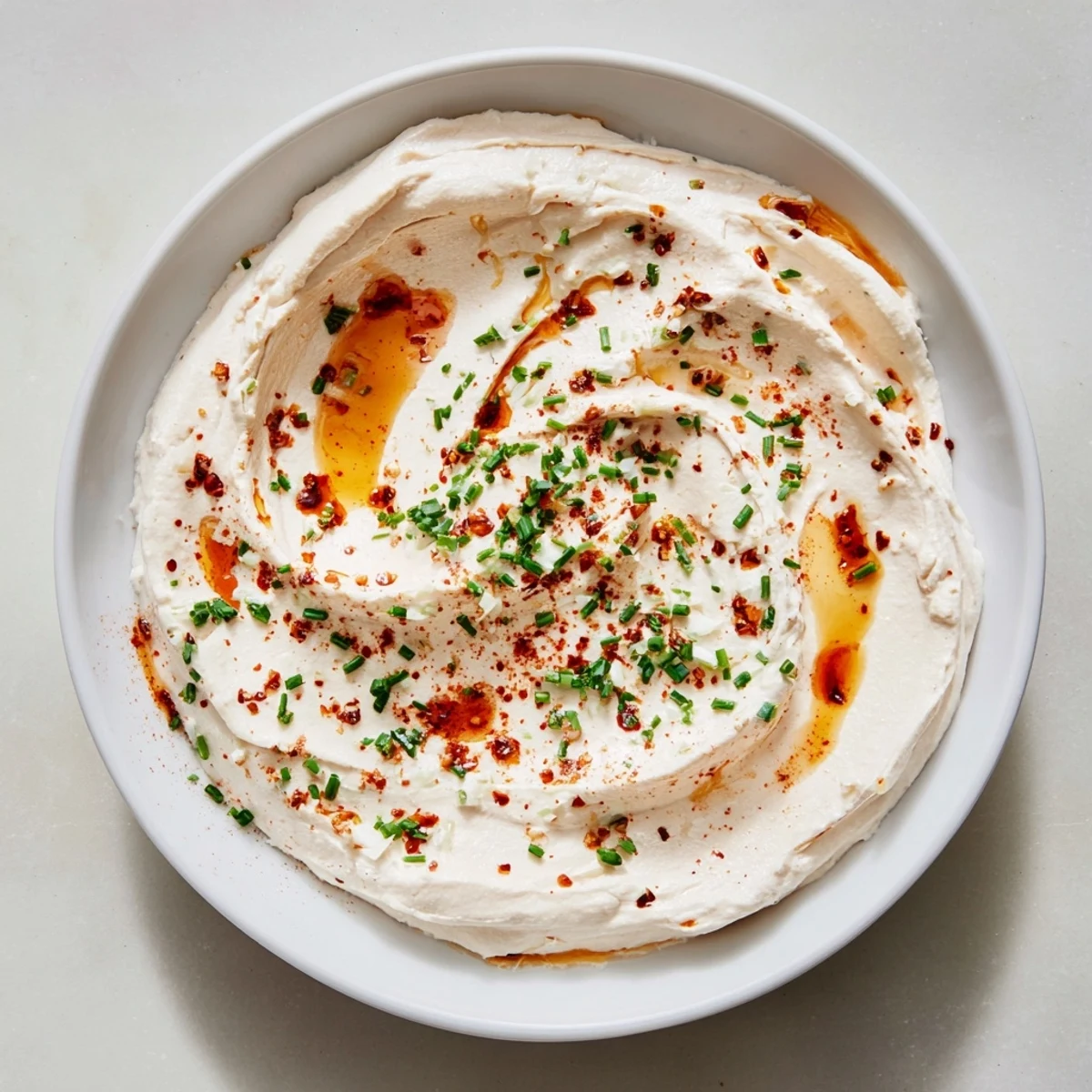 Creamy whipped ricotta dip with hot honey, drizzled and swirled for a spicy flavor explosion.