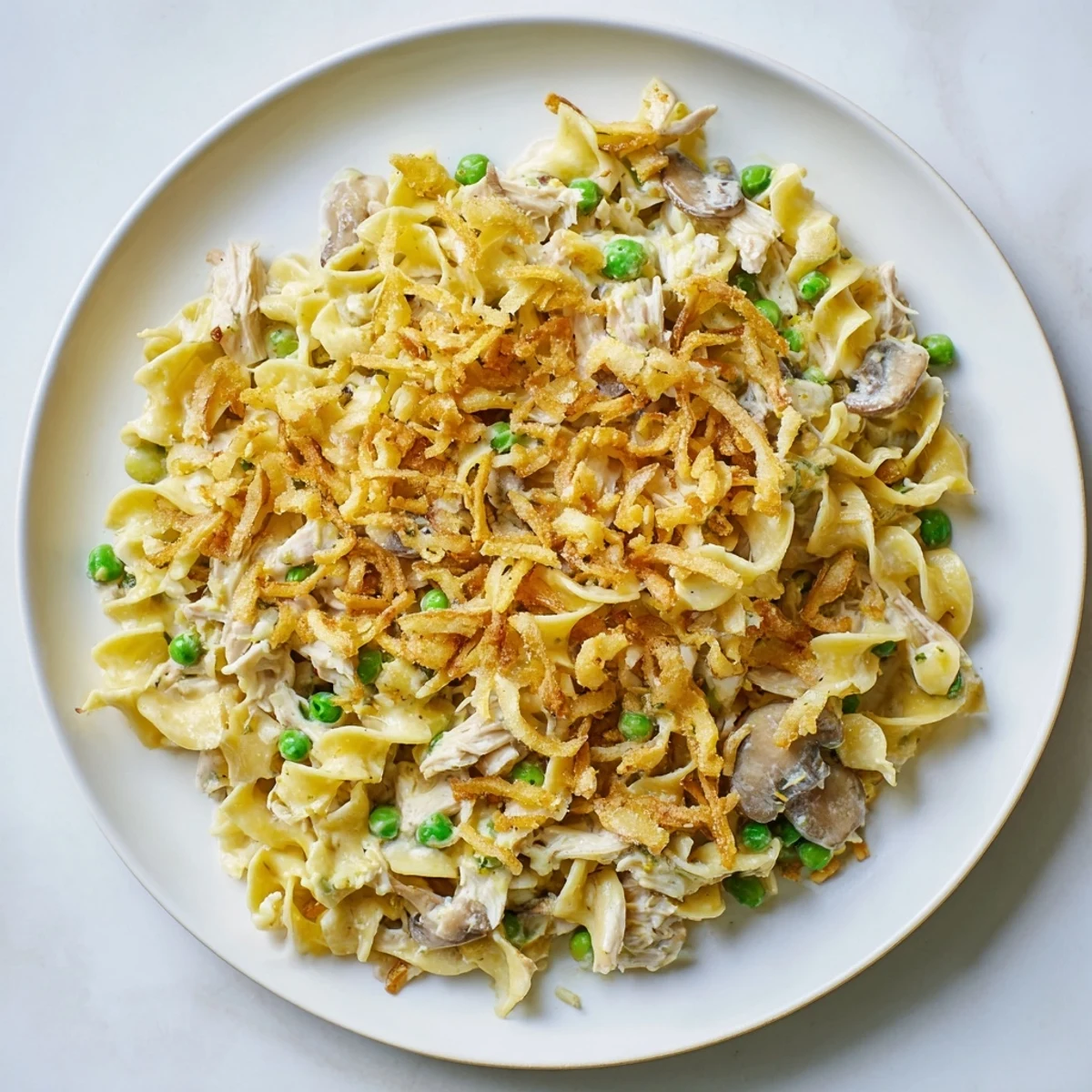 Creamy tuna noodle casserole with golden crispy onions, ready to serve with a bubbly, savory filling.