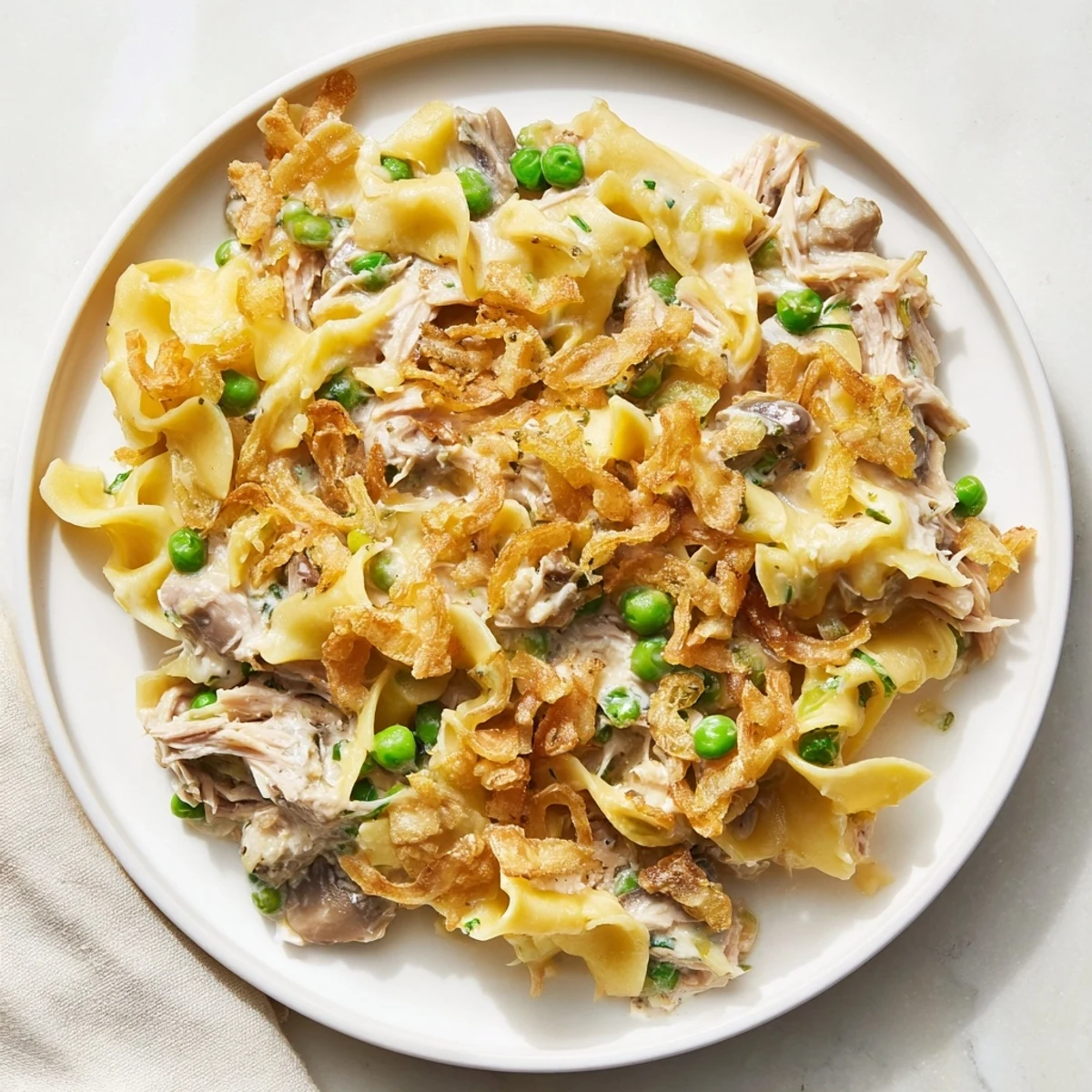 Warm and inviting, this creamy tuna noodle casserole features tender noodles and a crispy onion topping.