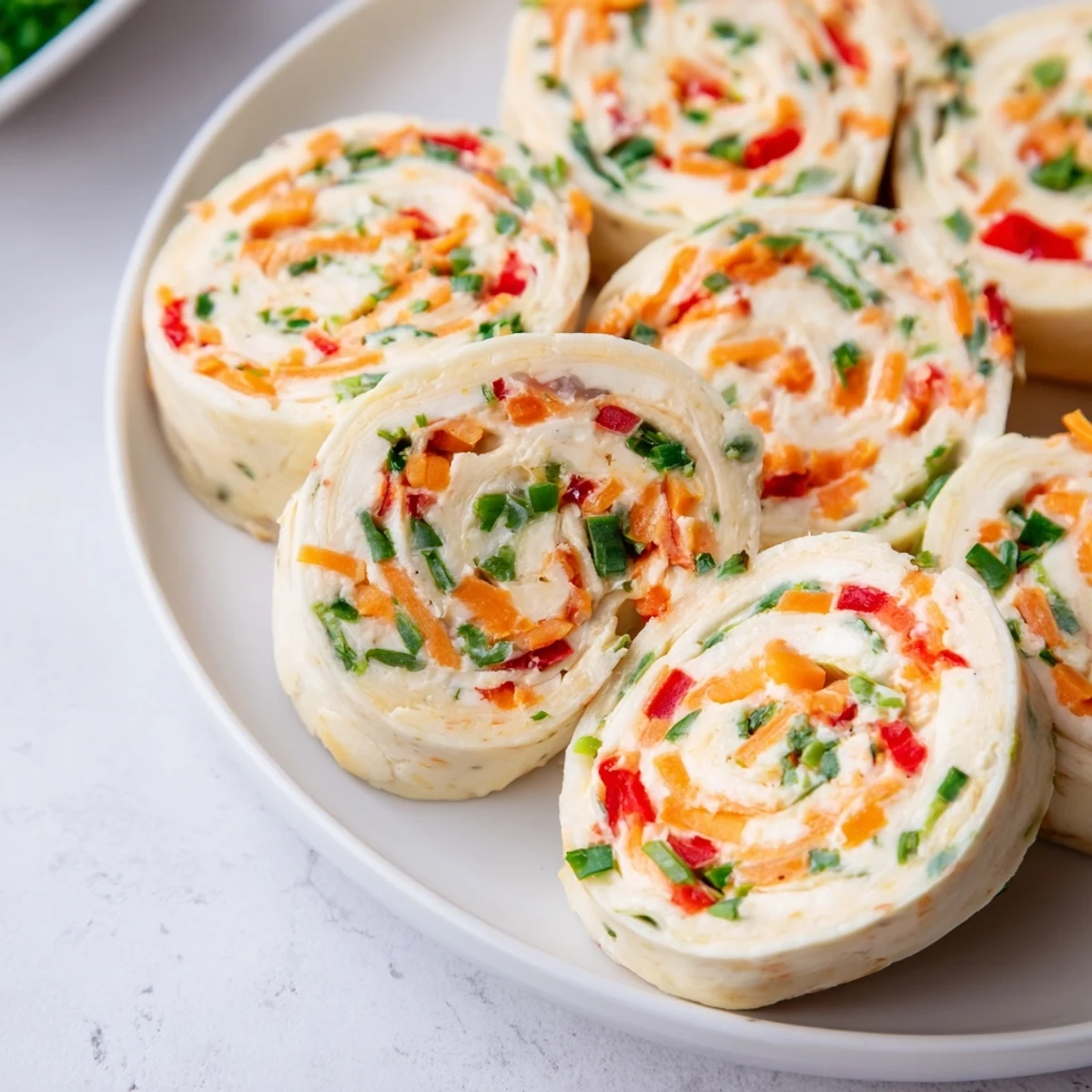 Cozy Scarf Holiday Pinwheel Wraps: Colorful, festive tortilla pinwheels filled with creamy cheese and fresh veggies.