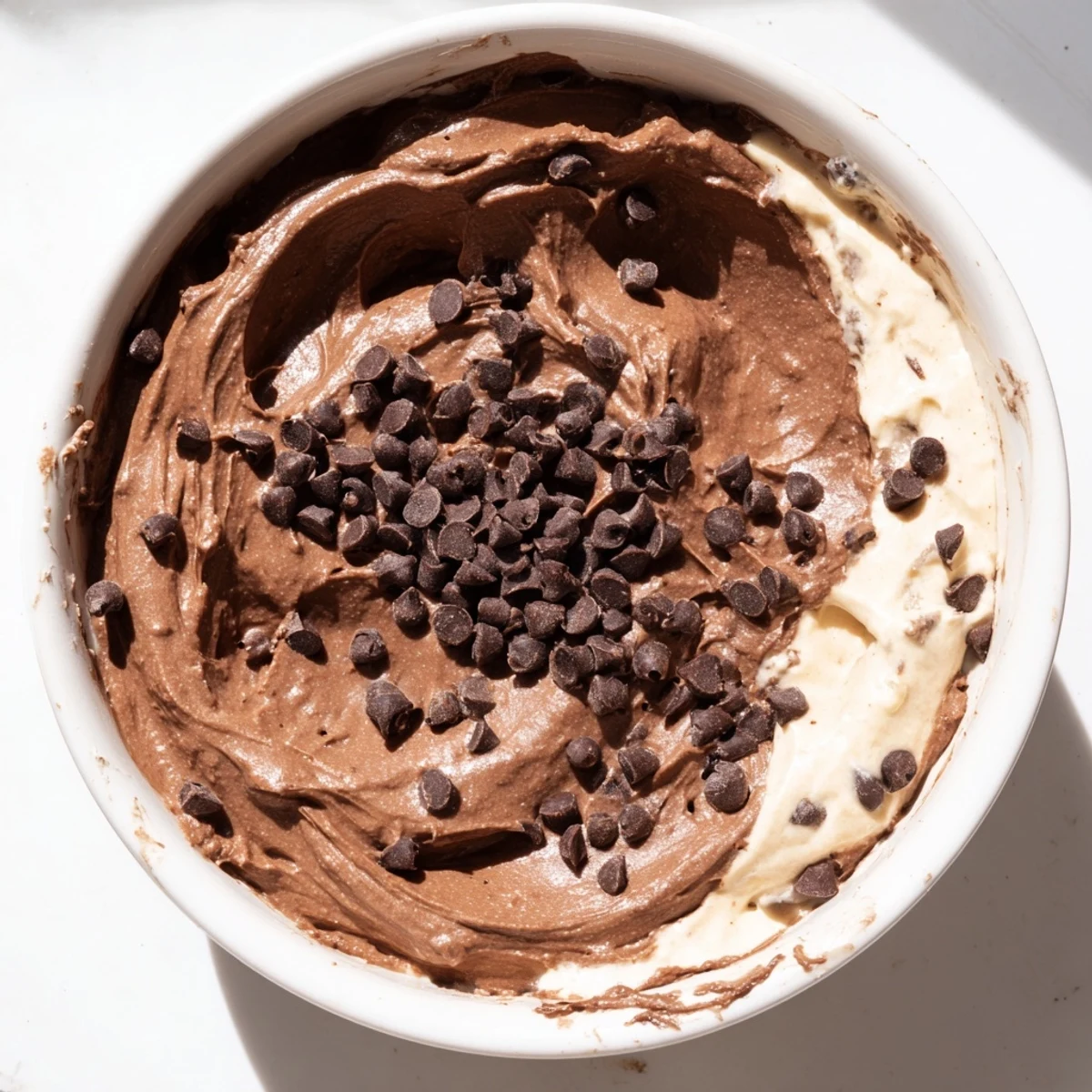 Creamy and tempting brownie batter dip is spooned, ready to dip apples or pretzels.