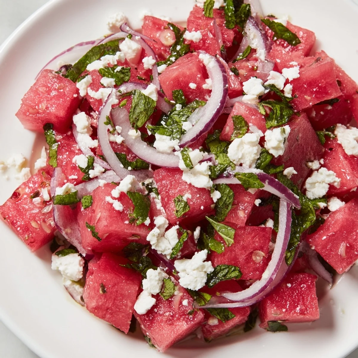 Fresh watermelon feta salad tossed with mint and lime dressing, perfect for warm days.