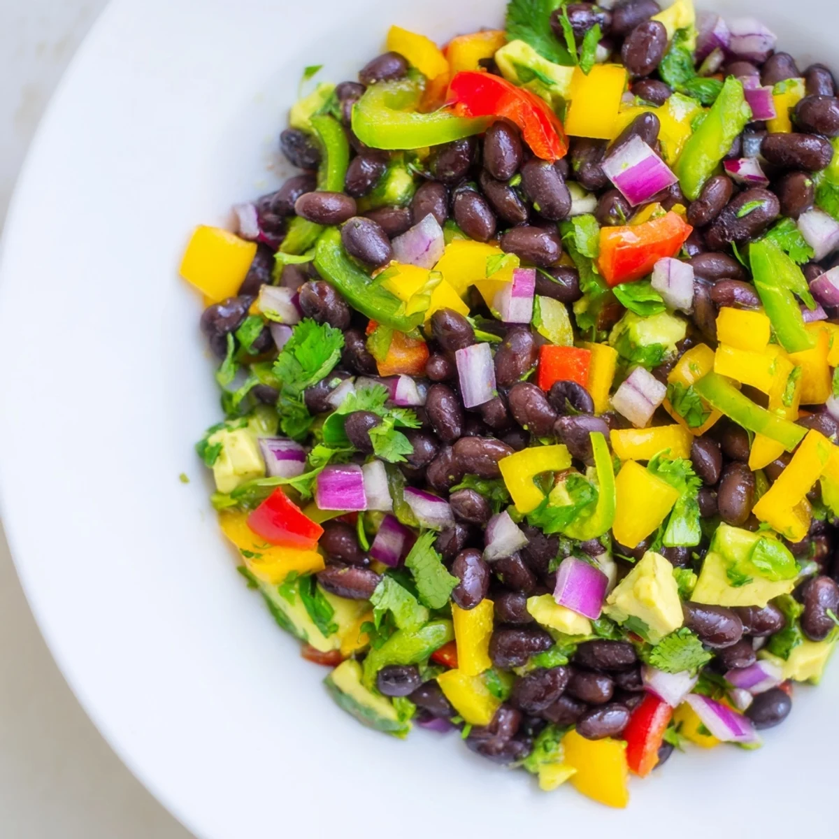 A colorful Southwest Black Bean Salad, full of crunchy vegetables and a zesty lime dressing.