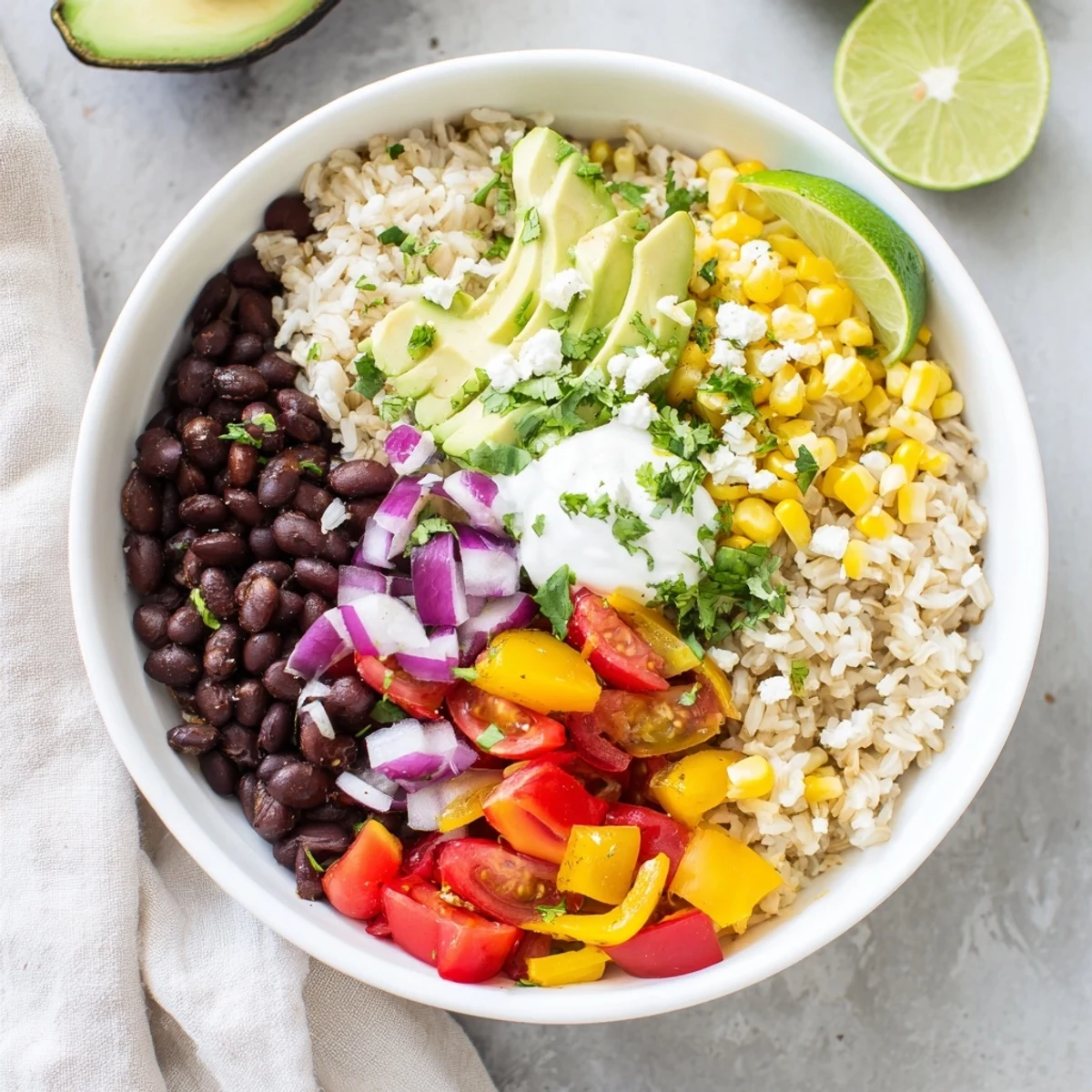 Vibrant Mexican-inspired brown rice burrito bowl featuring beans, veggies, cheese, and creamy avocado.