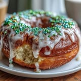 Soft, baked King Cake donuts topped with creamy vanilla glaze and bold green, purple, and gold sprinkles for a celebratory Mardi Gras treat.