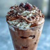 Fluffy Yogurt Protein Mousse with Cocoa and Sea Salt in a glass, topped with flaky sea salt and fresh berries.