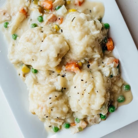 Golden-brown Chicken and Dumplings Casserole bubbling in a baking dish, ready to serve and enjoy.