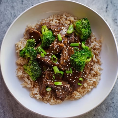 Close-up of slow-cooker beef & broccoli, showing tender beef and vibrant broccoli florets in savory sauce.