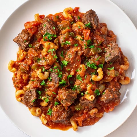 Steaming goulash with beef and tender pasta, a hearty and flavorful dish ready to enjoy.