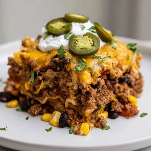 Steaming hot Taco Lasagna, layered with cheese and beef, ready to serve with fresh garnishes.