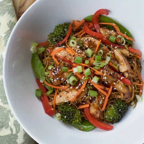 Sheet-Pan Crispy Ramen with chicken features golden noodles, vibrant veggies, and tender chicken pieces.