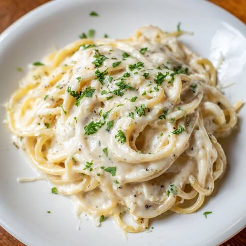 Steaming bowl of creamy three-cheese spaghetti, a comforting Italian-American pasta dish.
