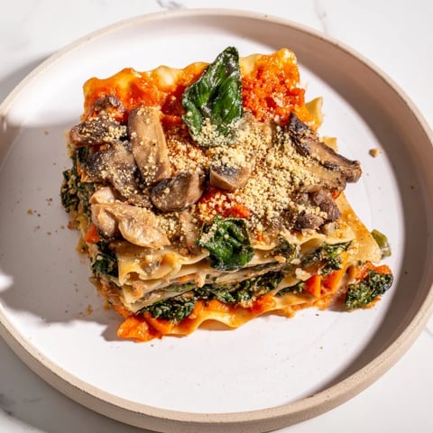 Steaming layers of Vegan Mushroom Spinach Lasagna, ready to be sliced and served for dinner.