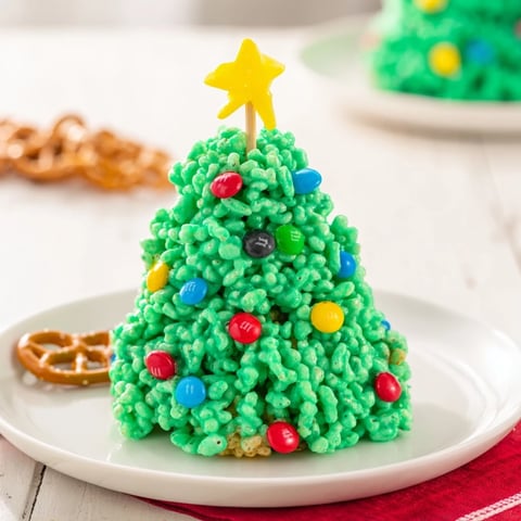 Freshly frosted Christmas Tree Rice Crispy Treats, adorned with colorful candies for a festive dessert.