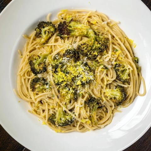 A vibrant bowl of Roasted Garlic Lemon Broccoli Angel Hair Pasta, ready to serve with Parmesan.