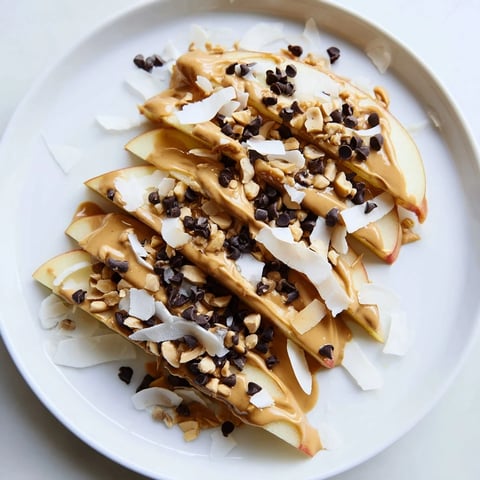 Crisp apple slices covered in peanut butter, a delightful Peanut Butter Apple Nachos snack.