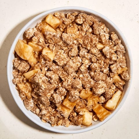 A generous slice of Best Apple Crisp with a scoop of vanilla ice cream, perfect dessert.