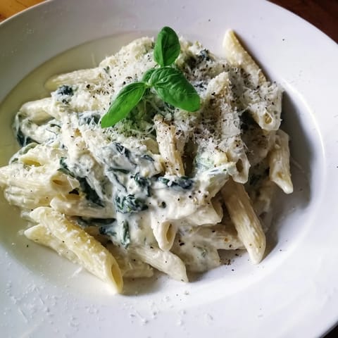 Creamy, green Cottage Cheese Spinach Pasta, ready to enjoy with a generous sprinkle of Parmesan cheese.