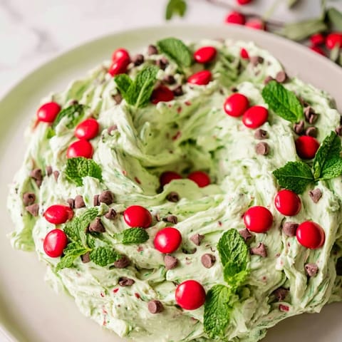 Cool creamy Mint Chocolate Chip Dip Wreath, a dessert perfect with cookies and festive garnishes.