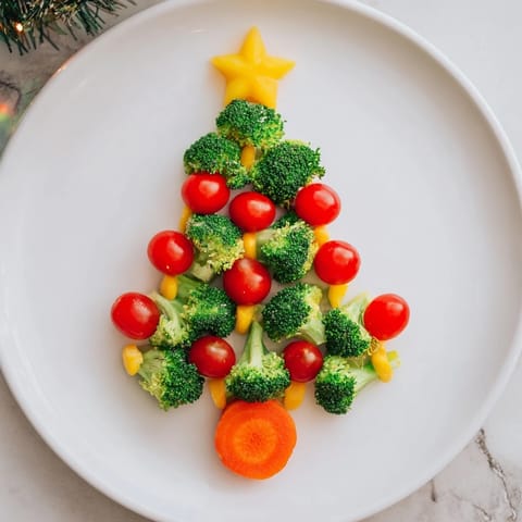 Festive Broccoli Tree showcasing cherry tomatoes as colorful ornaments, served with creamy dip.