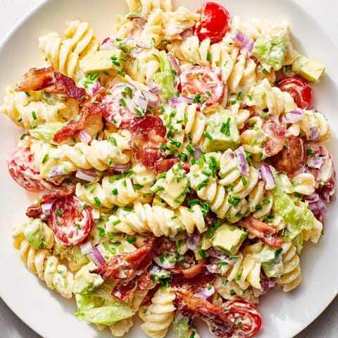 Vibrant BLT Pasta Salad, featuring ripe tomatoes, crisp bacon, and fresh romaine lettuce.