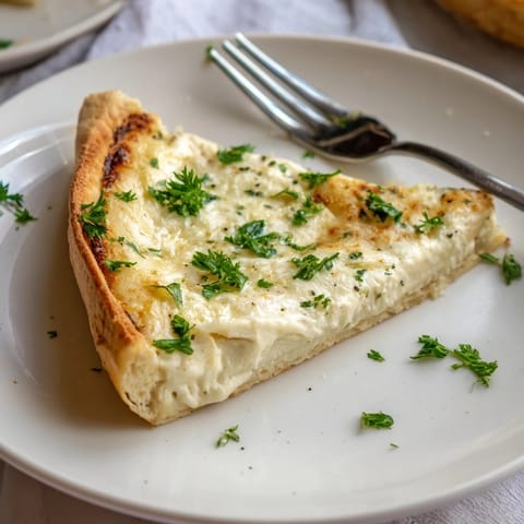 Sliced Creamy Garlic White Pizza showing bubbly cheese and velvety garlic cream sauce on a rustic wooden board.  