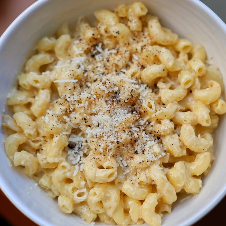 Homemade mug mac & cheese with Parmesan topping, perfect for an easy single-serving microwave meal.