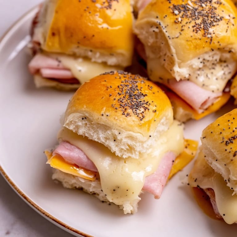 Warm, bubbling ham and cheese sliders, drizzled with a sweet glaze, ready to enjoy with family.