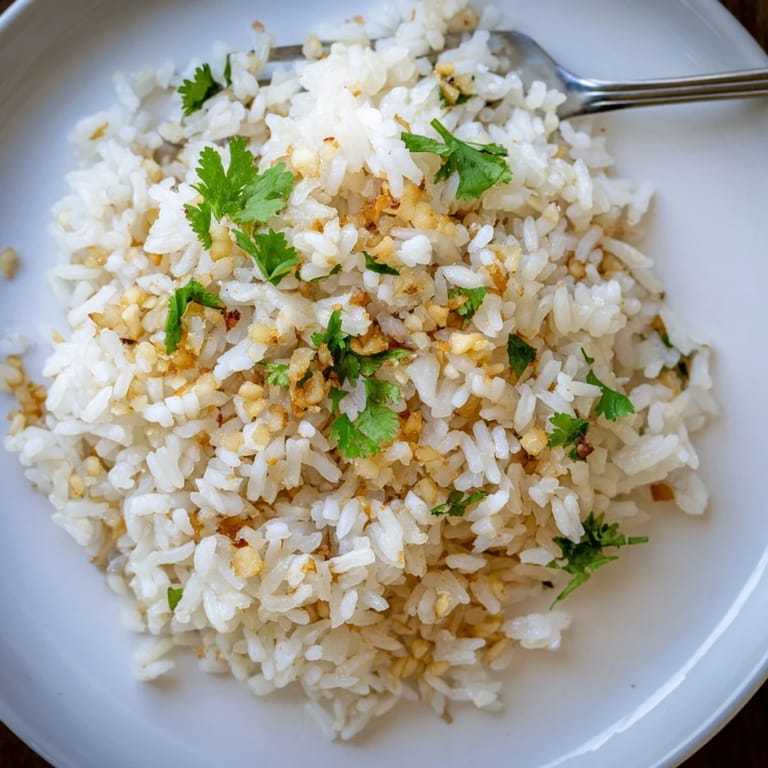 A close-up photo shows fragrant jasmine rice garlic grains glistening with oil, paired with grilled vegetables or tofu for a complete meal.