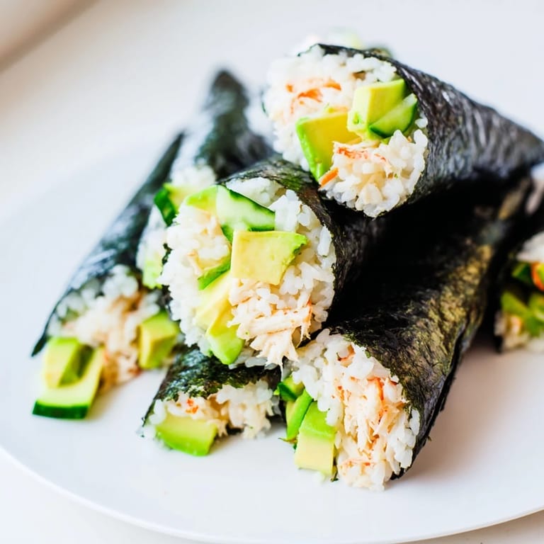 Sushi Rice Hand Rolls filled with seasoned rice, shredded crab, and fresh vegetables served with soy sauce and wasabi.  