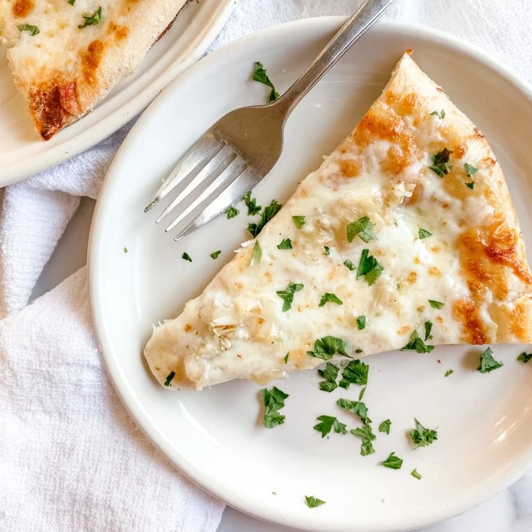 Close-up of Creamy Garlic White Pizza with steam rising, showcasing melted mozzarella and a perfectly crisp crust.