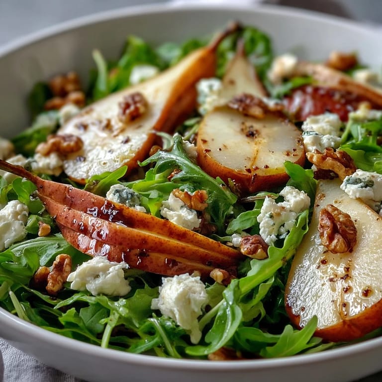 A close-up of a colorful Arugula and Pear Bowl, showcasing peppery greens, sweet pear slices, blue cheese crumbles, and toasted walnuts for a refreshing salad.
