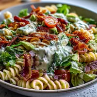 Fresh BLT Pasta Salad with crispy bacon, creamy avocado, and juicy cherry tomatoes in a tangy dressing.  